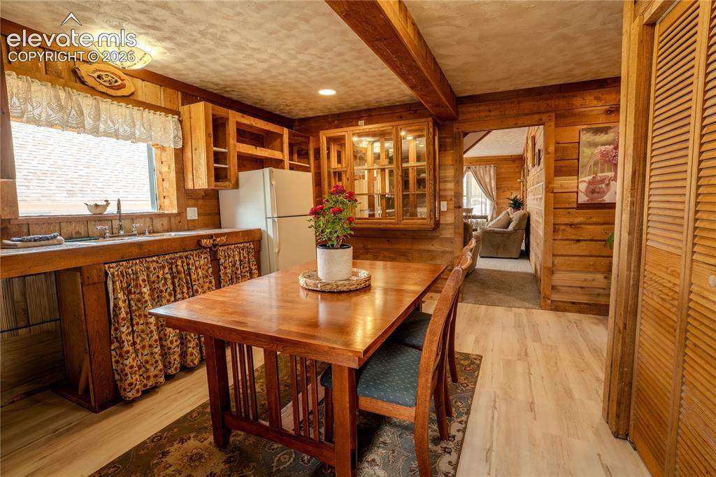 Image 15 of 40: Kitchen and dining area featuring natural wood paneling, wood-finish floori