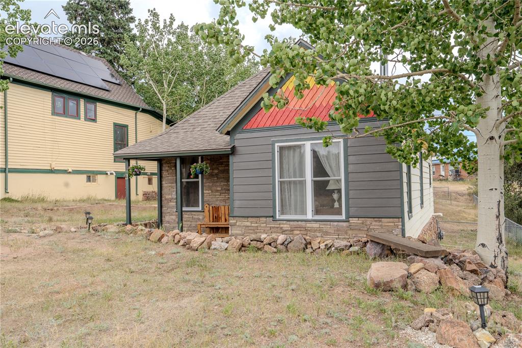 Image 2 of 40: Charming home exterior featuring horizontal siding, a covered porch with st