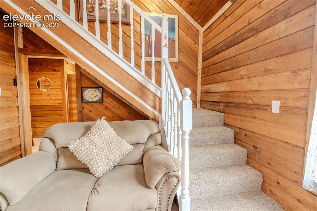 Image 23 of 40: Carpeted staircase with white balusters and handrails, complemented by exte