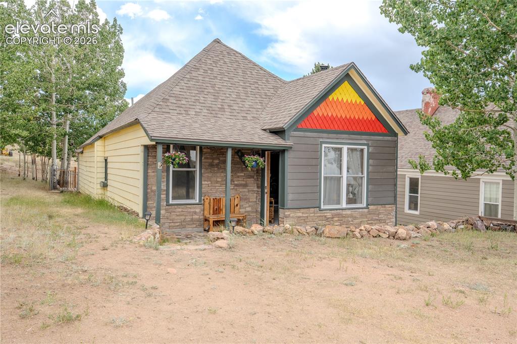 Image 3 of 40: Facade featuring variegated horizontal siding, stone veneer accents, and a