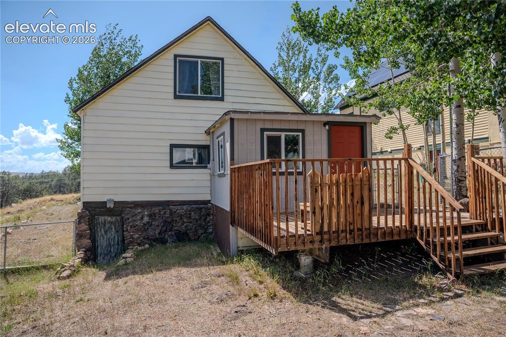 Image 36 of 40: Rear exterior featuring a multi-level wood deck with wood railings, an atta