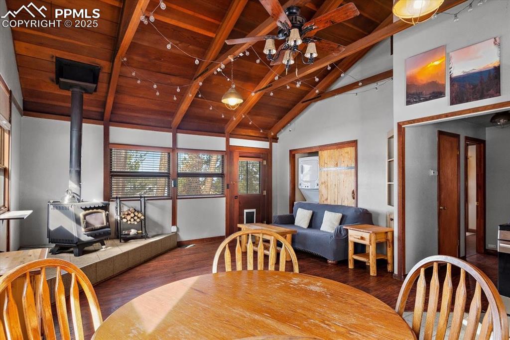 Image 10 of 25: Dining space featuring a wood stove, wooden ceiling, ceiling fan, and wood