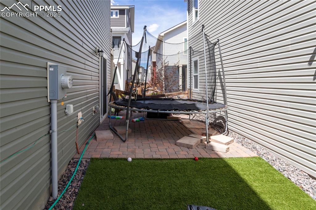 Image 45 of 48: Level yard with grass and paver patio