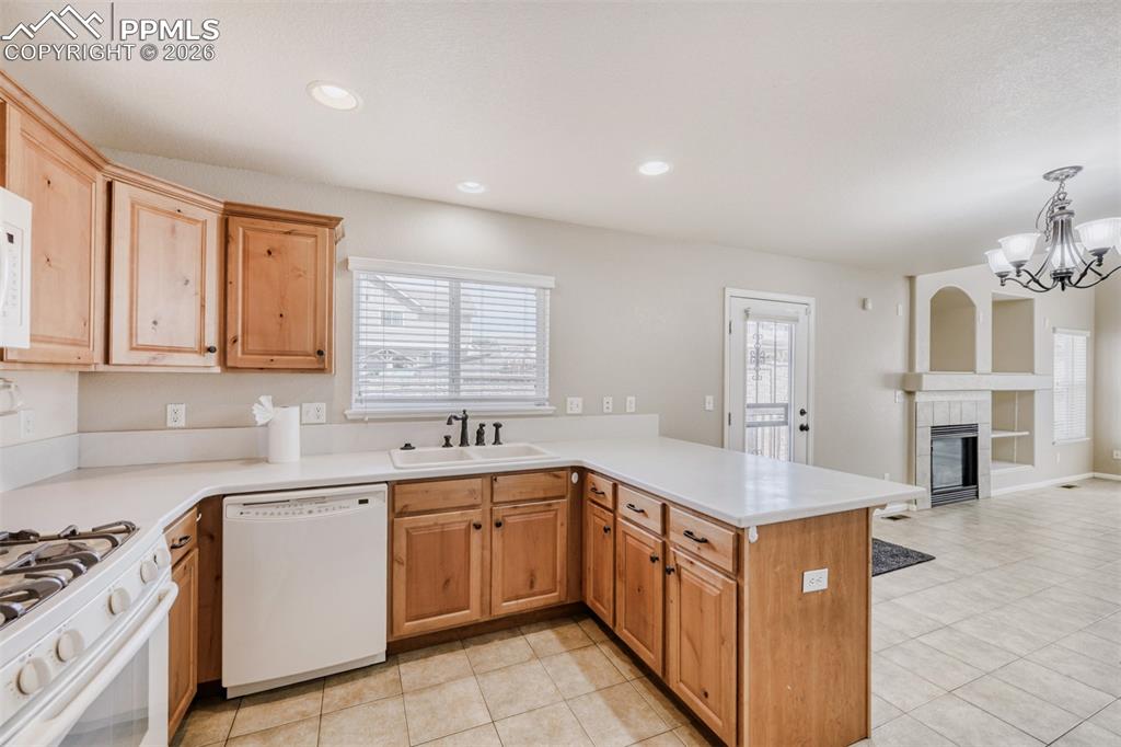 Image 8 of 28: Kitchen featuring white appliances, Corian solid countertops, a peninsula w