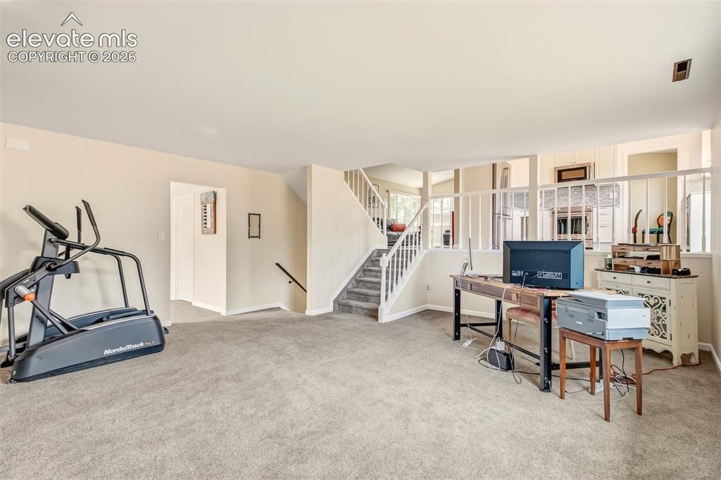 Image 22 of 39: Family room with wood burning fireplace on lower level