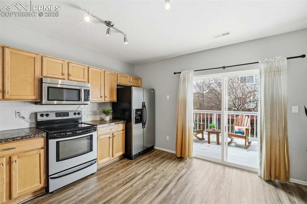 Image 12 of 44: Contemporary kitchen featuring wood-finish flooring, light wood cabinetry, 
