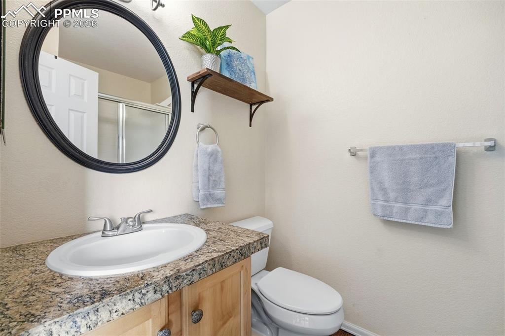 Image 18 of 44: Bathroom vanity featuring a speckled countertop and an oval undermount sink