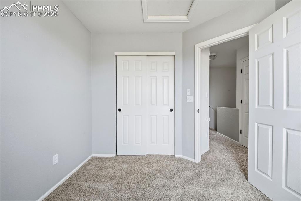 Image 23 of 44: Carpeted room featuring a white paneled bi-fold closet door, light gray pai