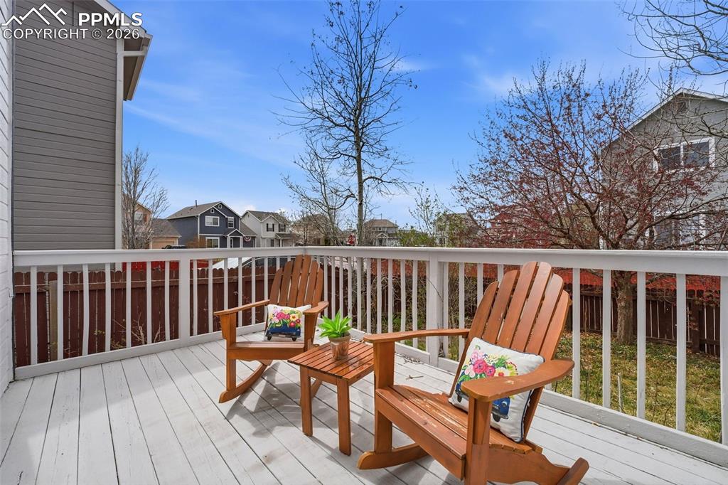 Image 26 of 44: Outdoor deck with white railing, featuring a gray siding exterior