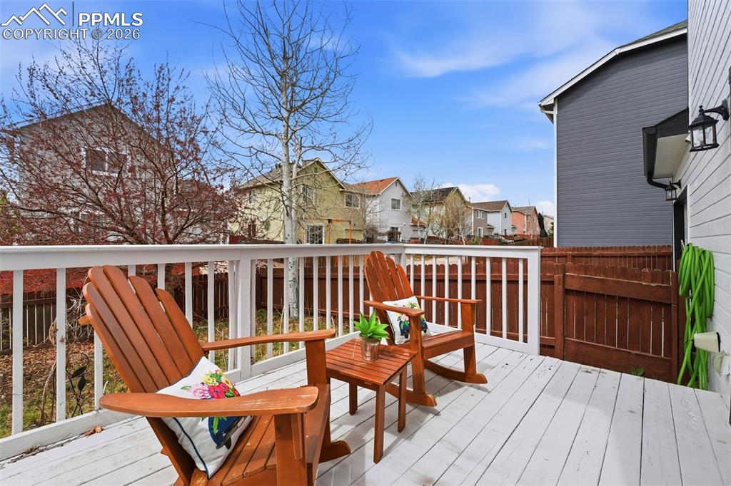 Image 27 of 44: Expansive outdoor deck featuring painted wood planks and a white railing sy