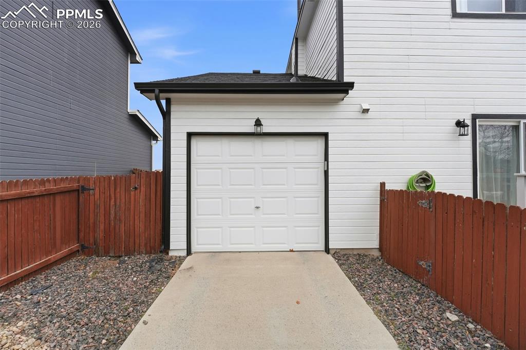 Image 32 of 44: Rear-facing garage with white paneled door, complemented by white horizonta