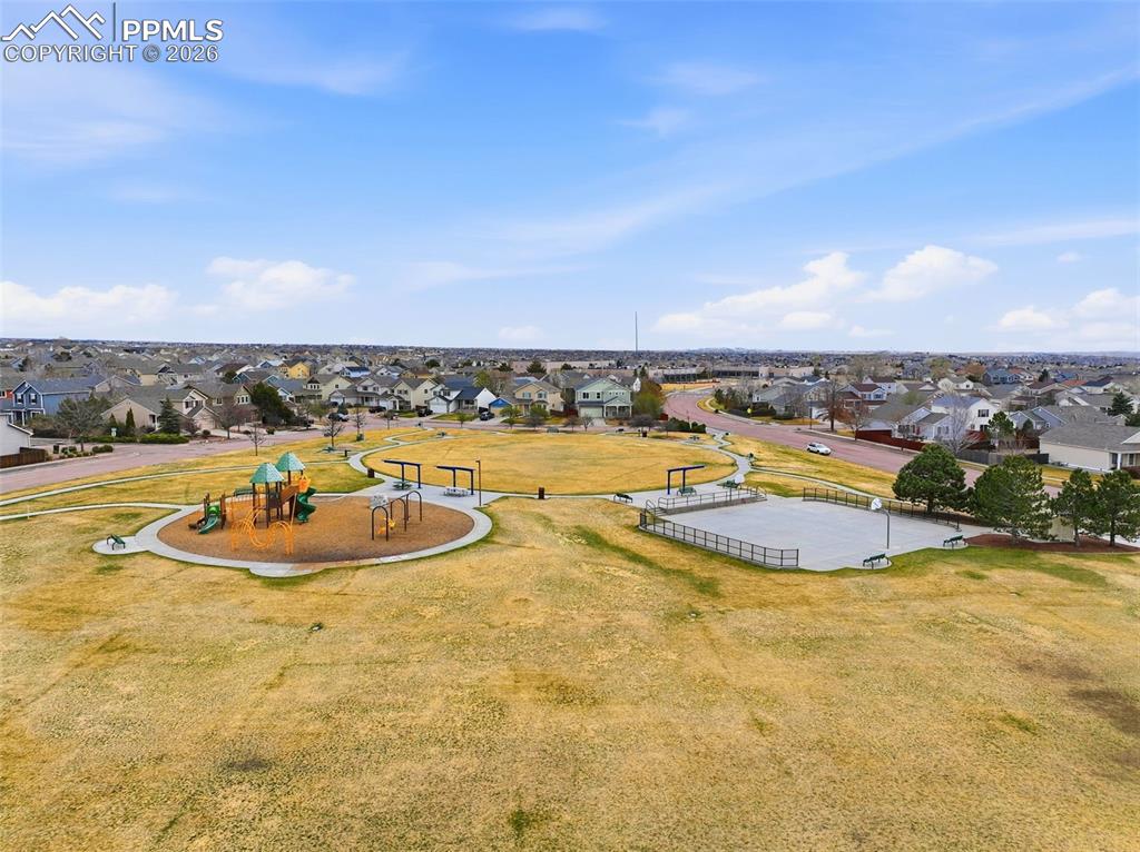 Image 33 of 44: Expansive community park featuring a playground area with soft ground cover