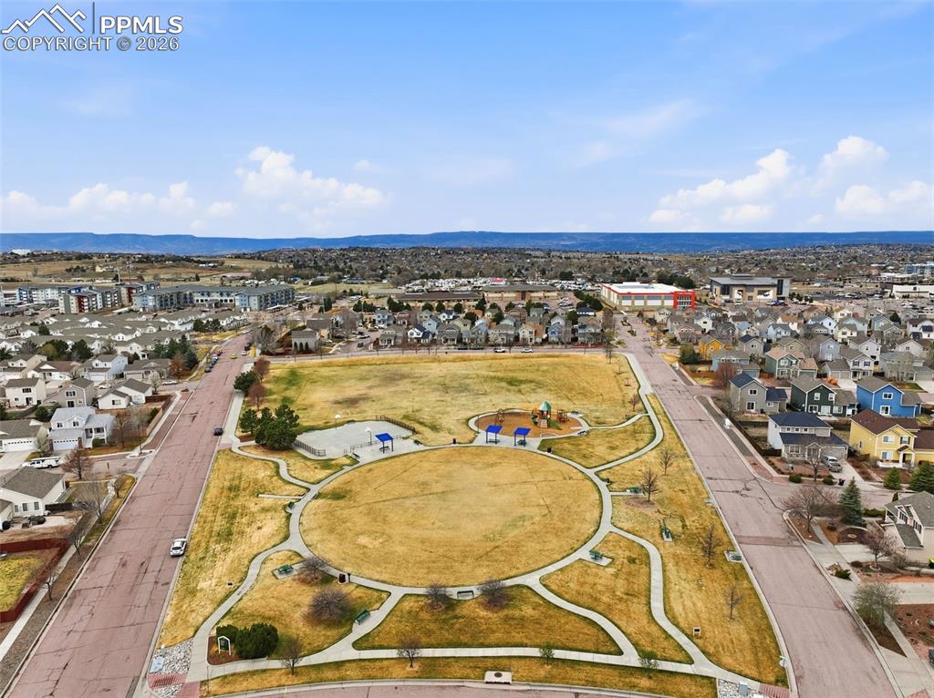 Image 34 of 44: Expansive community green space featuring walking paths, a circular lawn ar