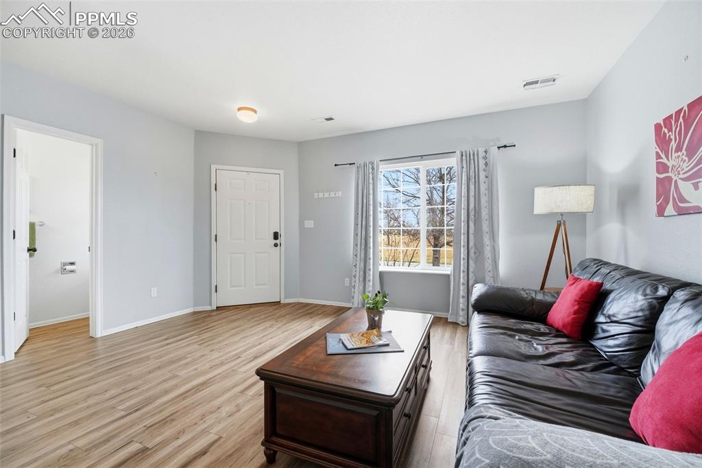 Image 6 of 44: Living area featuring wood-finish flooring, light gray walls, a white front