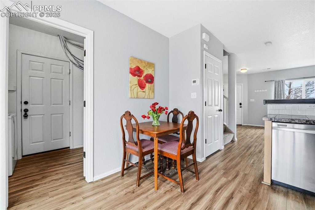 Image 8 of 44: Open-concept dining and kitchen area featuring wood-finish flooring, light 