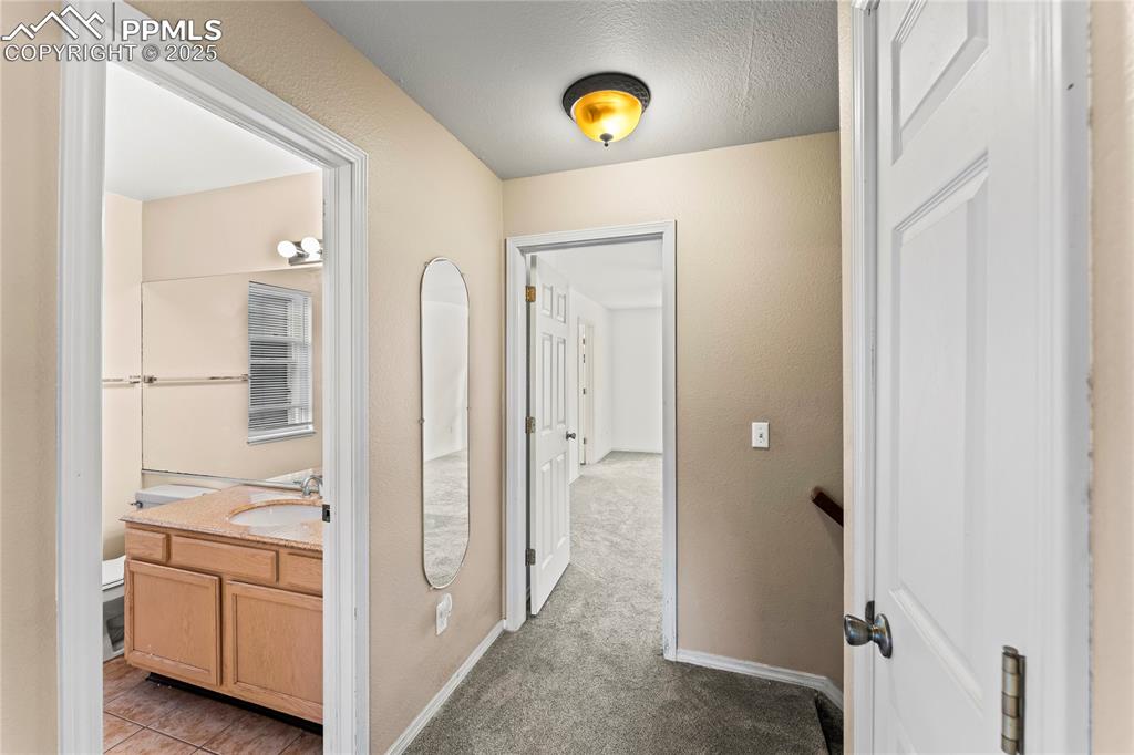 Image 31 of 38: Upstairs hallway looking into the primary bedroom