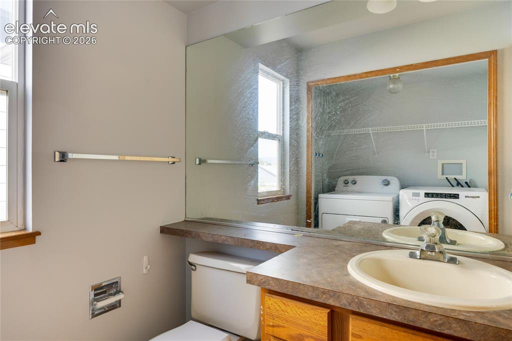 Image 13 of 34: Vanity with an integrated sink, built-in cabinetry, and a full-width mirror
