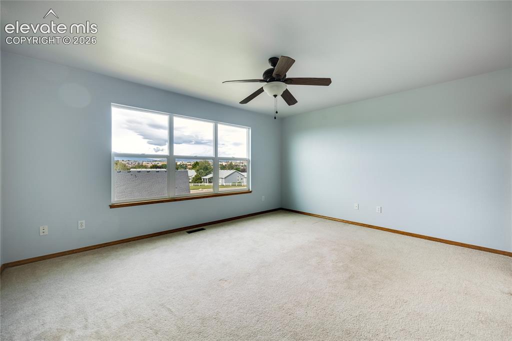 Image 15 of 34: Expansive room featuring light-colored carpeting, a multi-pane window with 