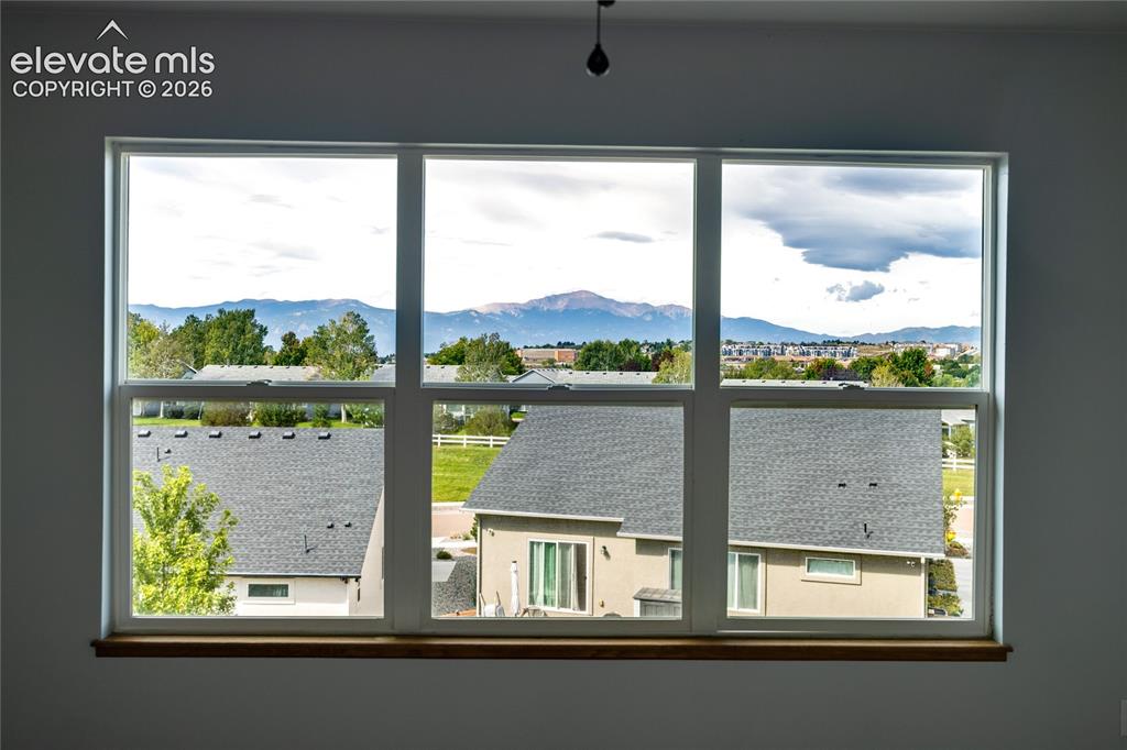 Image 17 of 34: Large multi-pane window with a wood-finish sill, showcasing a mountain back