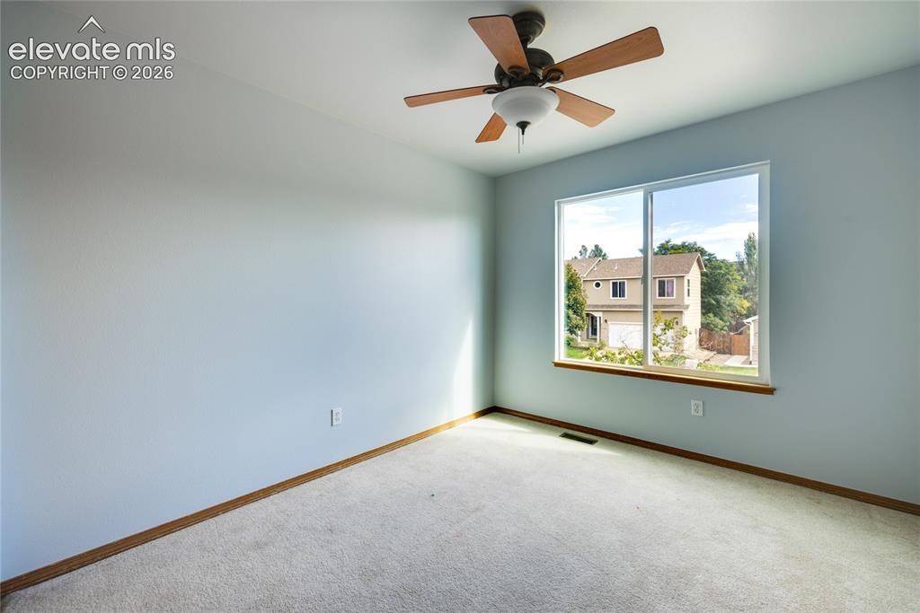 Image 21 of 34: Wall-to-wall carpeting, wood-finish ceiling fan with integrated lighting, a