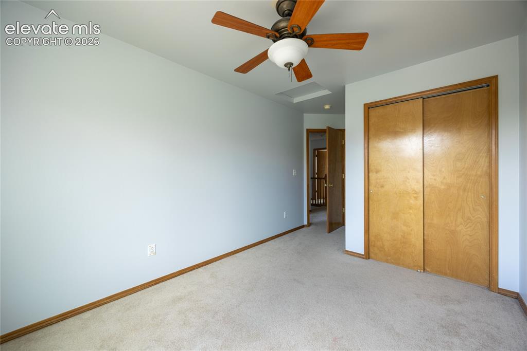 Image 22 of 34: Ceiling fan, neutral wall color, carpet flooring, wood-finish bi-fold close