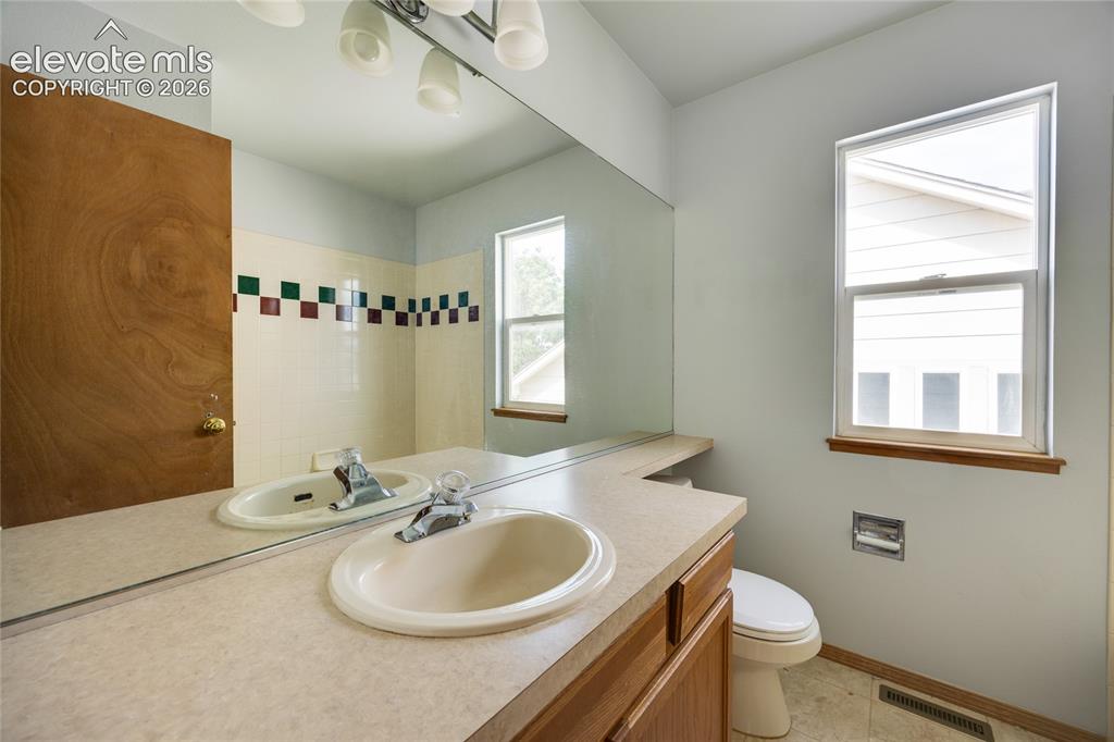 Image 23 of 34: Bathroom featuring a large vanity mirror, built-in vanity with integrated s