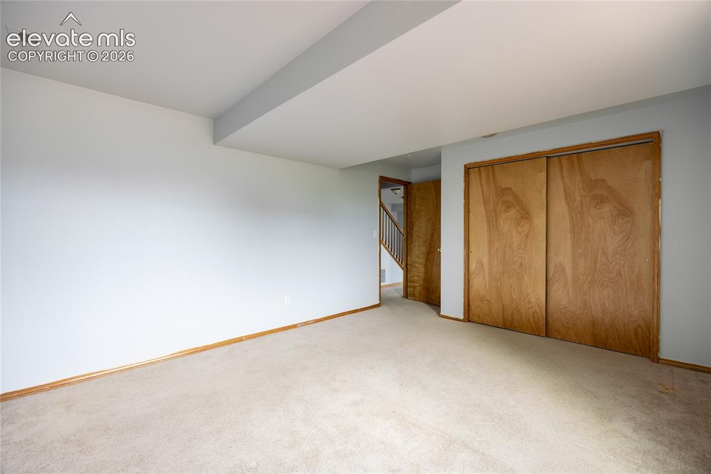 Image 27 of 34: Carpeted flooring, light wood-tone baseboards, light-toned walls, wood-tone