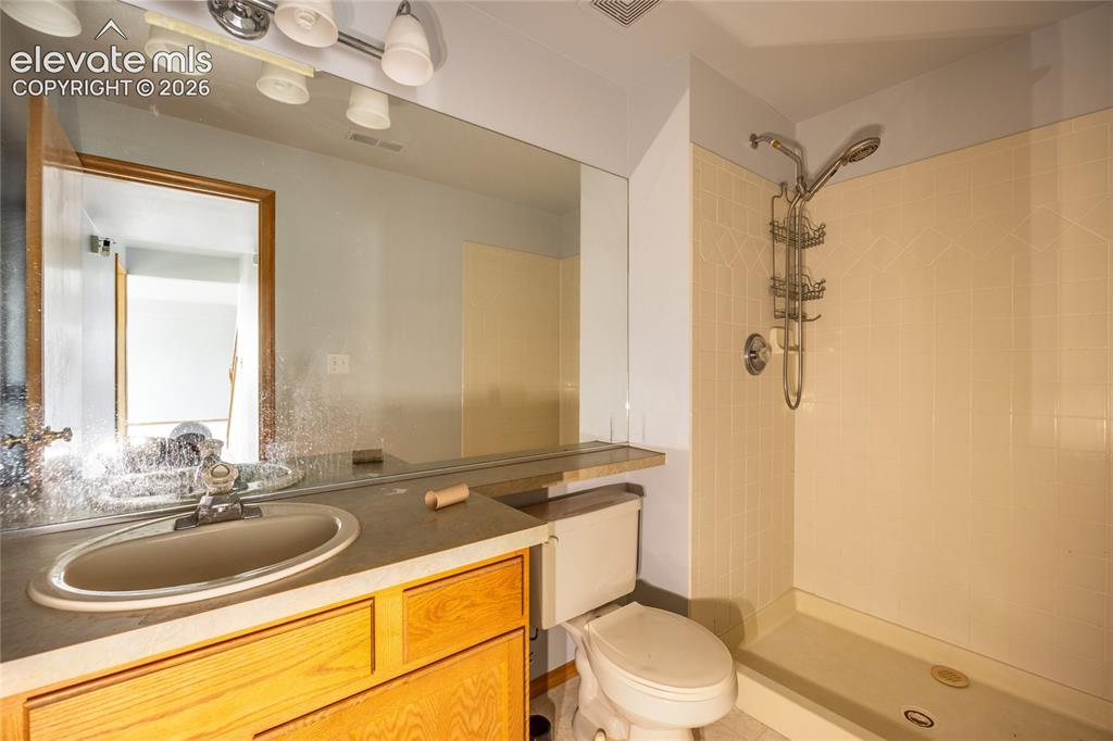 Image 28 of 34: Vanity with an integrated sink, broad counter space, wood-finish cabinetry,