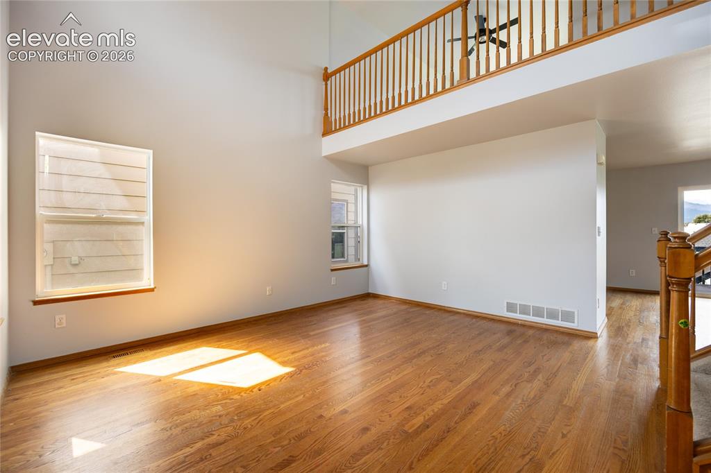 Image 3 of 34: Vaulted ceilings, wood-finish flooring, and a second-story interior balcony