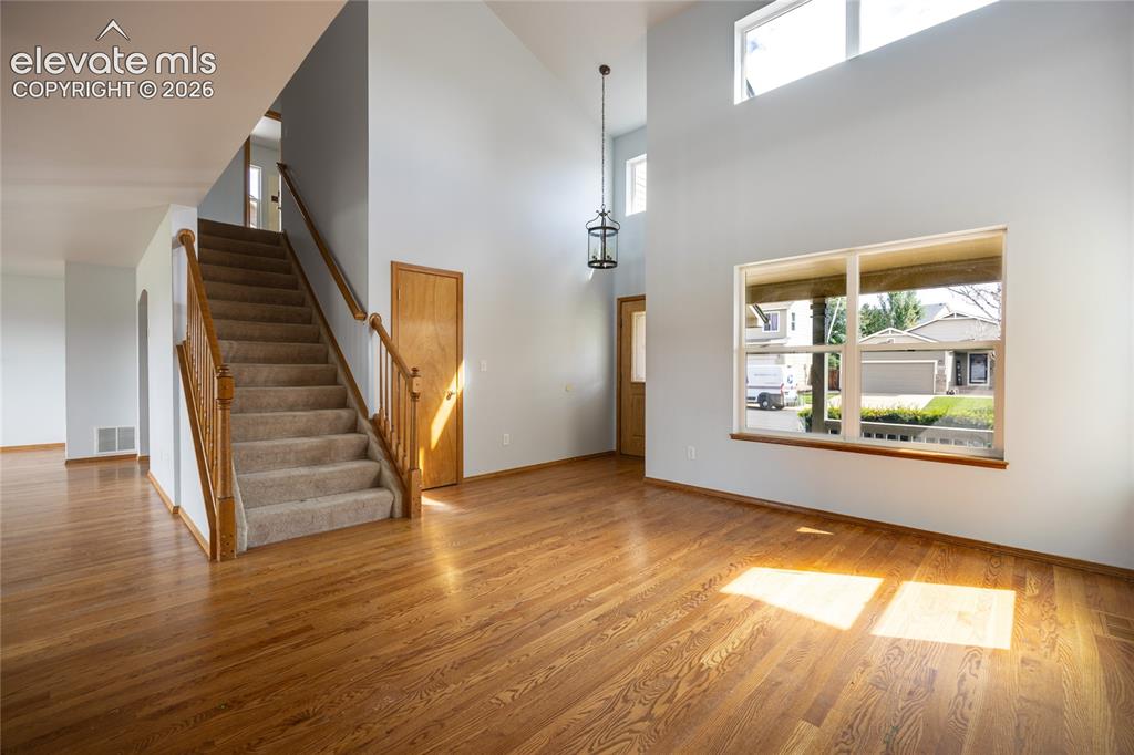 Image 5 of 34: Hardwood flooring throughout, a two-story entryway, and a large front-facin