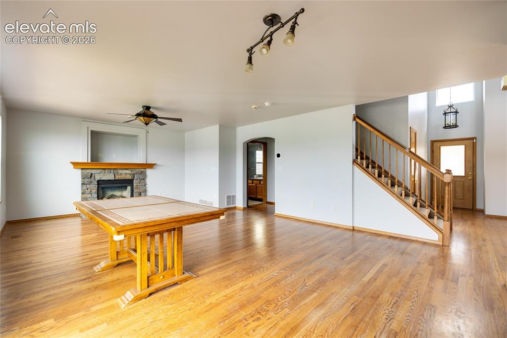 Image 7 of 34: Hardwood flooring, stone-faced fireplace with wood mantel, built-in ceiling