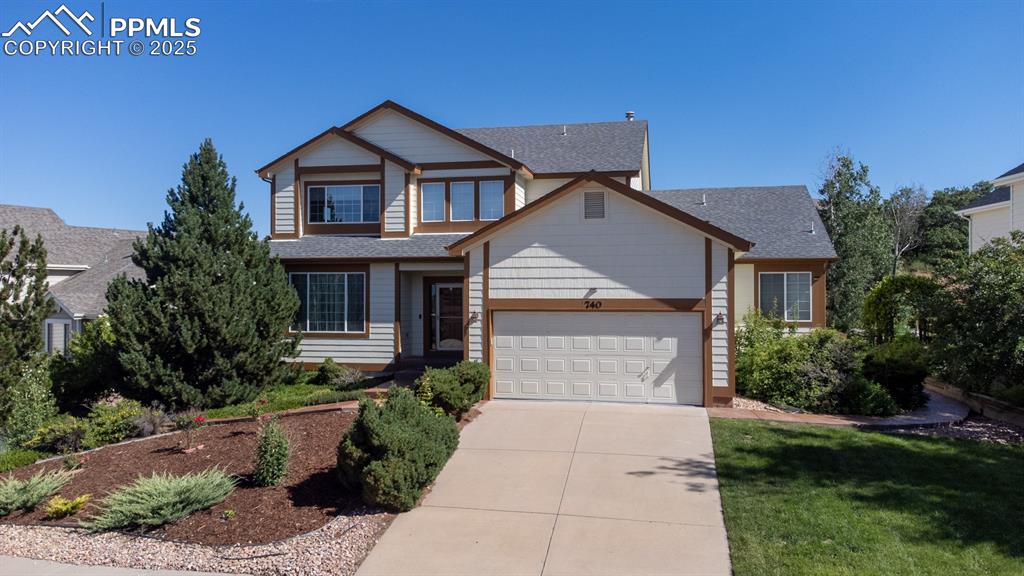 Caption: View of front of home with driveway, an attached garage, and a shingled roof