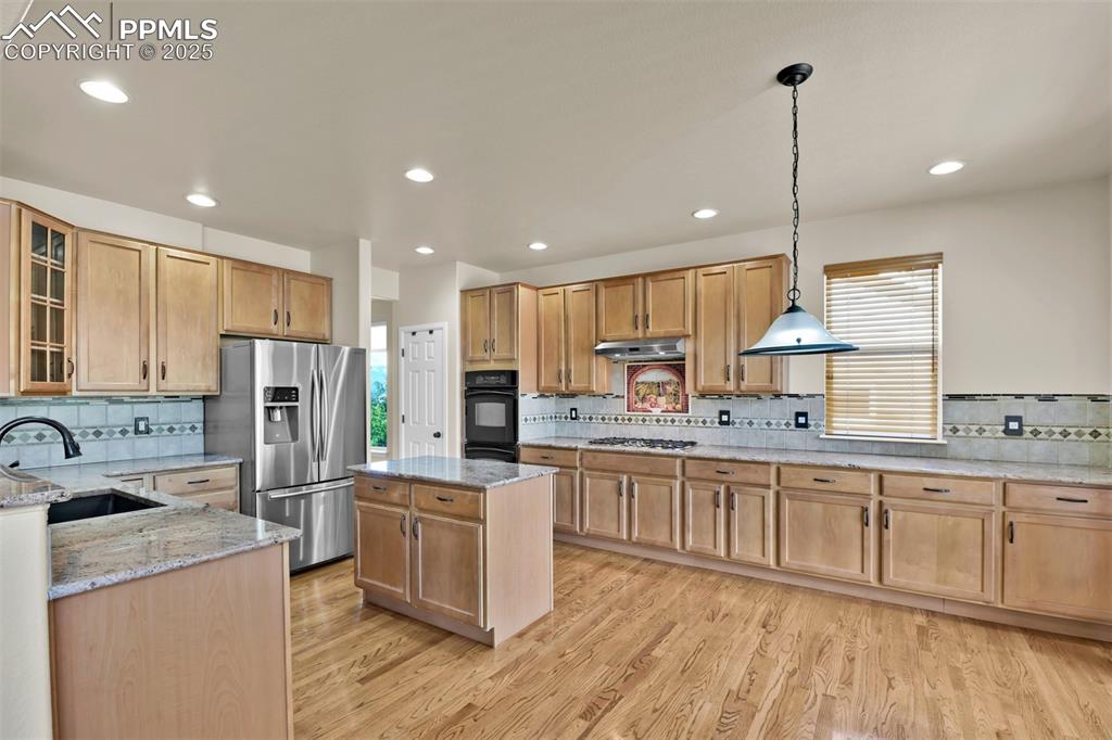 Image 11 of 50: Kitchen with appliances with stainless steel finishes, light stone counters