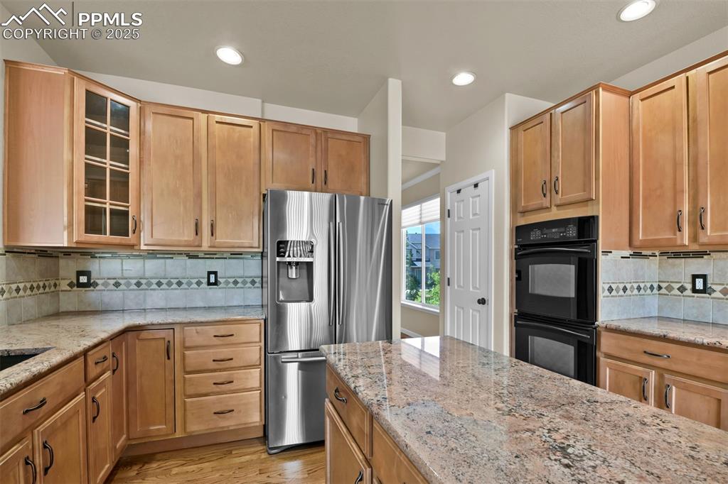 Image 15 of 50: Kitchen with stainless steel fridge with ice dispenser, glass insert cabine