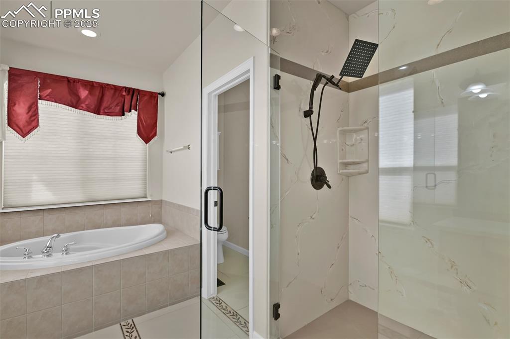 Image 29 of 50: Bathroom featuring a marble finish shower, a bath, and tile patterned floor