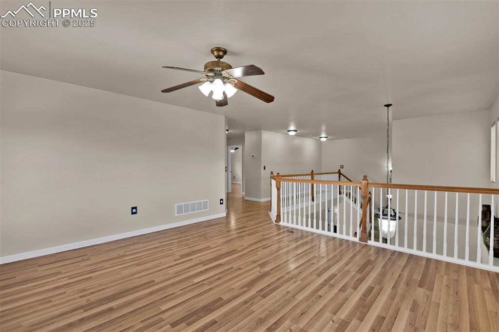 Image 35 of 50: Unfurnished room with ceiling fan and light wood finished floors