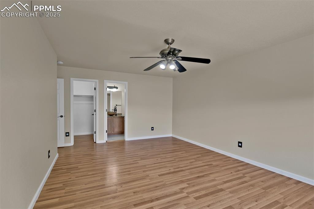 Image 37 of 50: Empty room with ceiling fan and light wood-style flooring