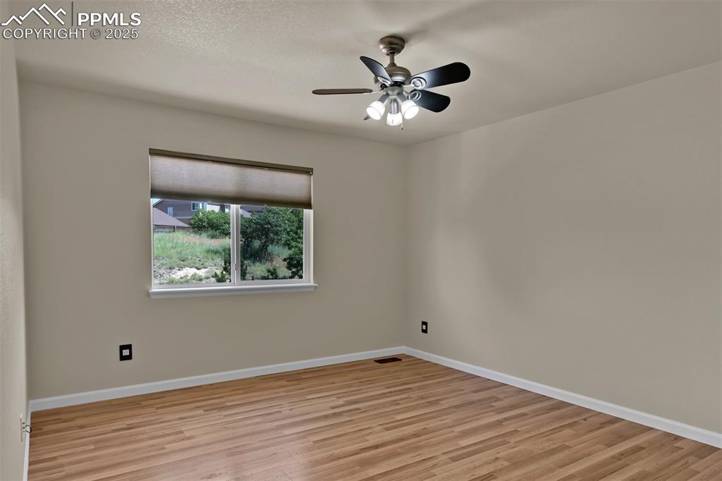 Image 40 of 50: Spare room with light wood finished floors and a ceiling fan