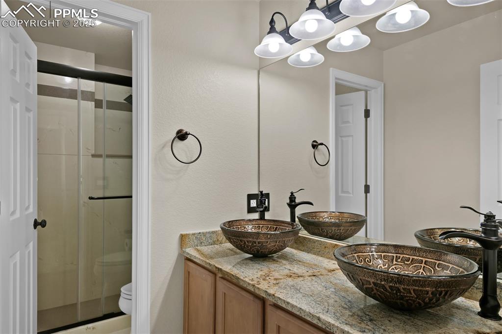 Image 42 of 50: Bathroom featuring a stall shower and double vanity