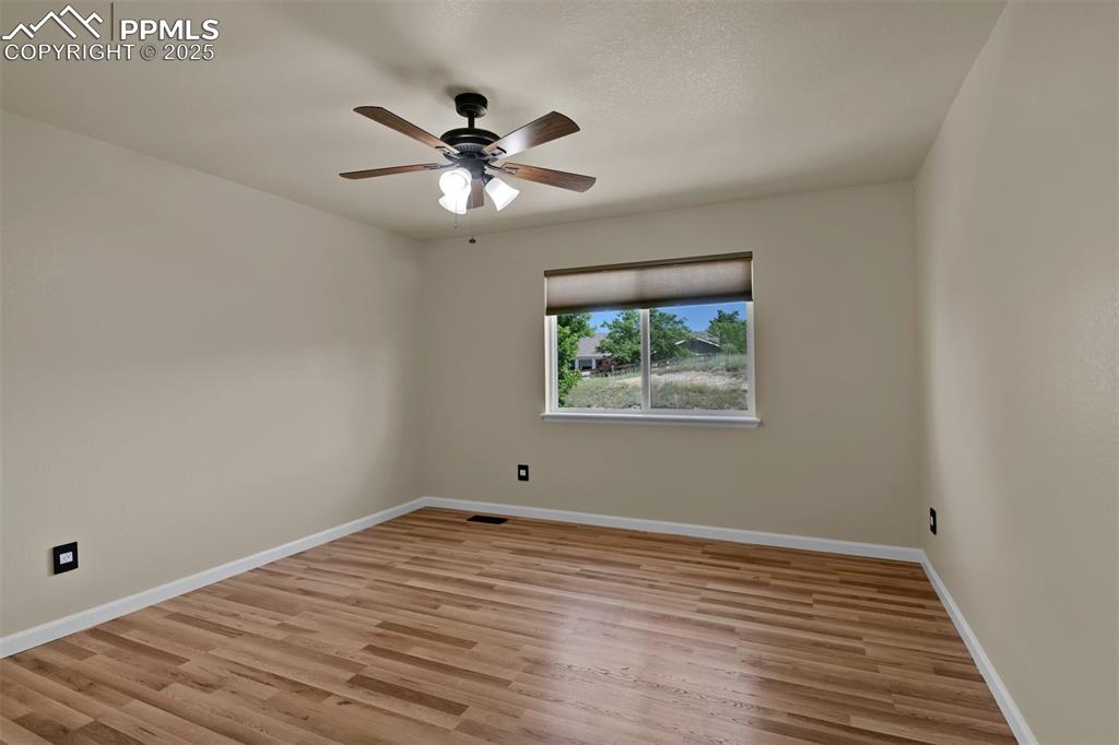 Image 44 of 50: Unfurnished room featuring light wood-type flooring and a ceiling fan