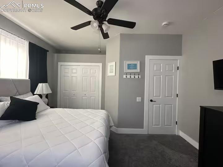 Image 14 of 23: Bedroom featuring a closet, ceiling fan, and dark colored carpet