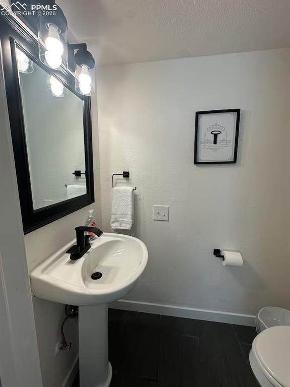 Image 17 of 23: Bathroom with a textured ceiling and dark wood-style flooring