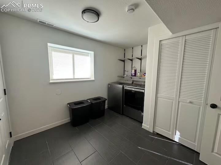 Image 21 of 23: Laundry area featuring washer and dryer and baseboards