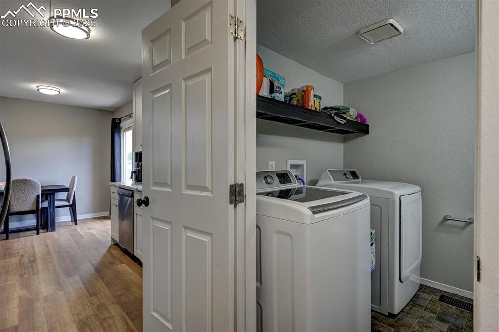 Image 18 of 33: Washroom featuring washing machine and dryer and a textured ceiling