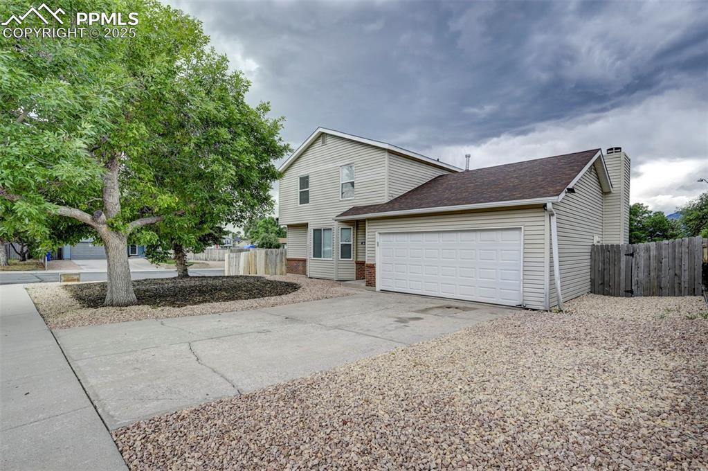 Image 2 of 33: View of front of property featuring an attached garage, concrete driveway,