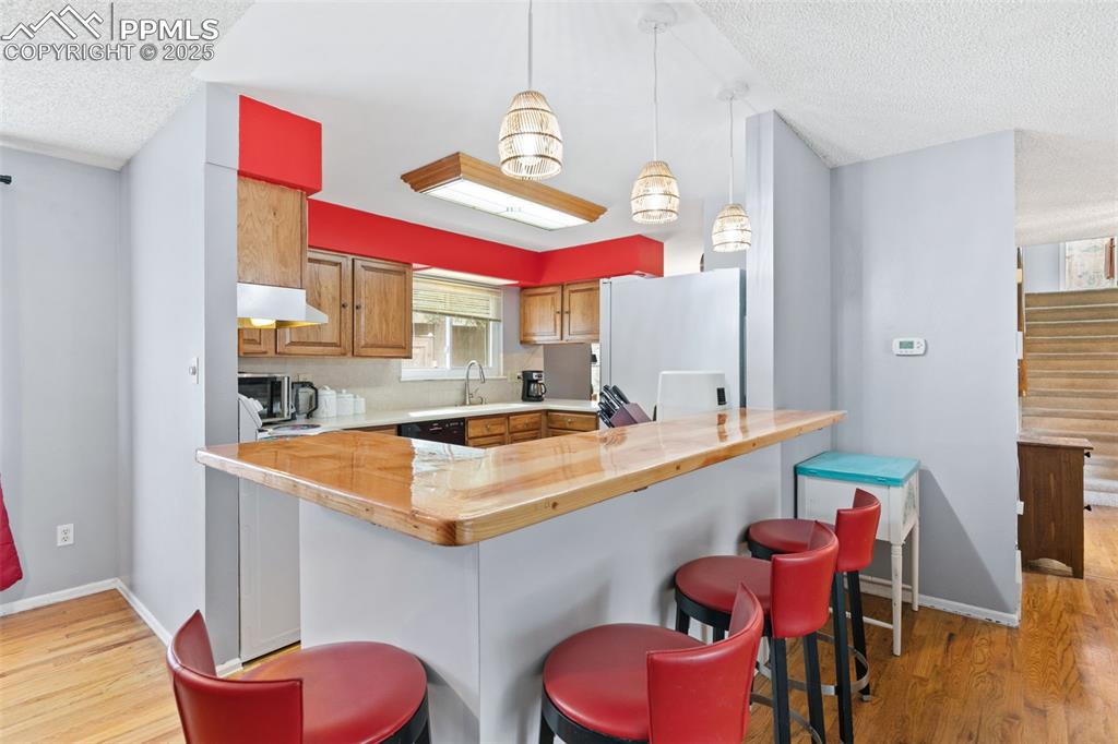 Image 10 of 36: Kitchen featuring light wood-style flooring, a textured ceiling, freestandi