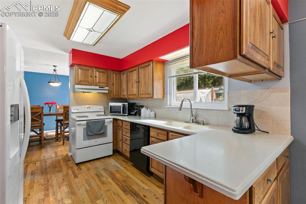 Image 13 of 36: Kitchen featuring light countertops, light wood-style floors, white applian