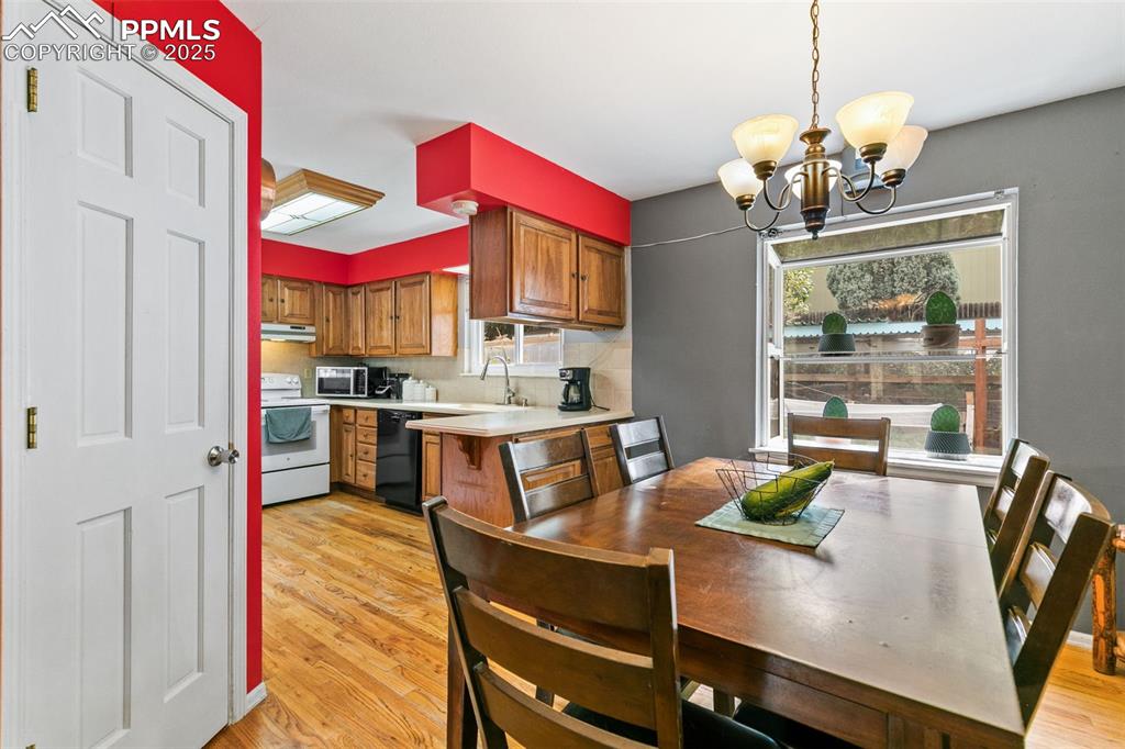 Image 17 of 36: Kitchen featuring light countertops, hanging light fixtures, light wood-sty
