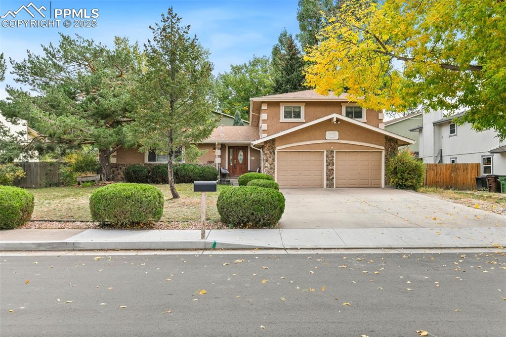 Image 2 of 36: Traditional-style house featuring stone siding, driveway, stucco siding, an