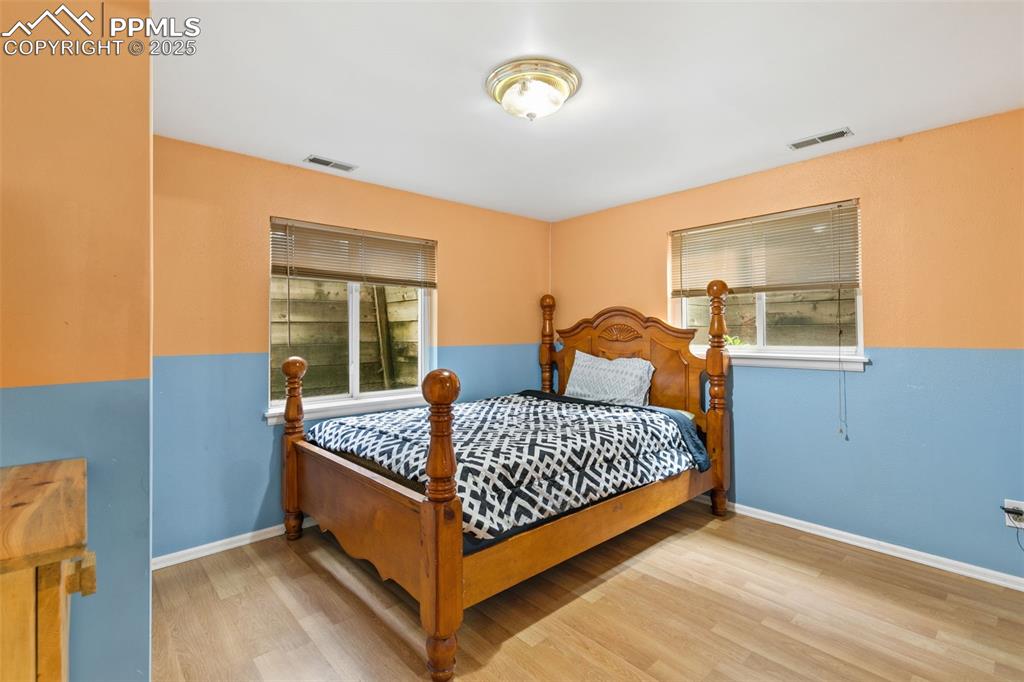 Image 31 of 36: Bedroom featuring multiple windows and wood finished floors